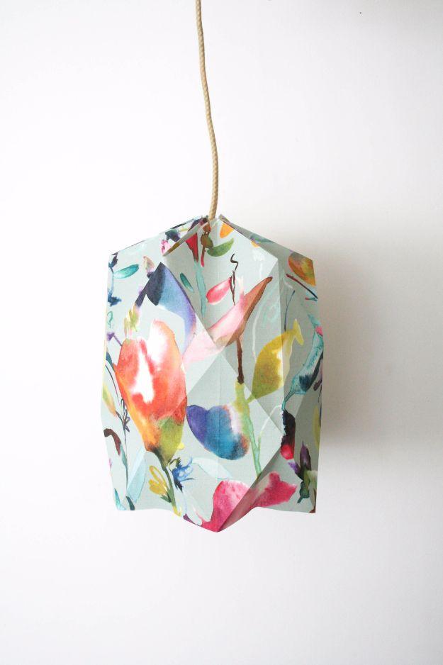 DIY origami lampshade, a folded geometric shade in watercolor floral wallpaper hanging from a cream cord against a white wall