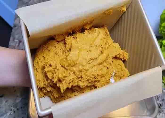 Transferring the pumpkin bread batter to the loaf pan