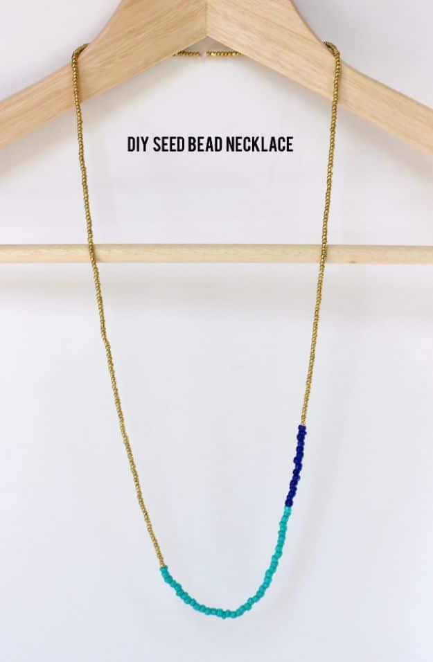 DIY seed bead necklace, a long gold seed bead strand with turquoise and royal blue sections hanging on a wooden hanger