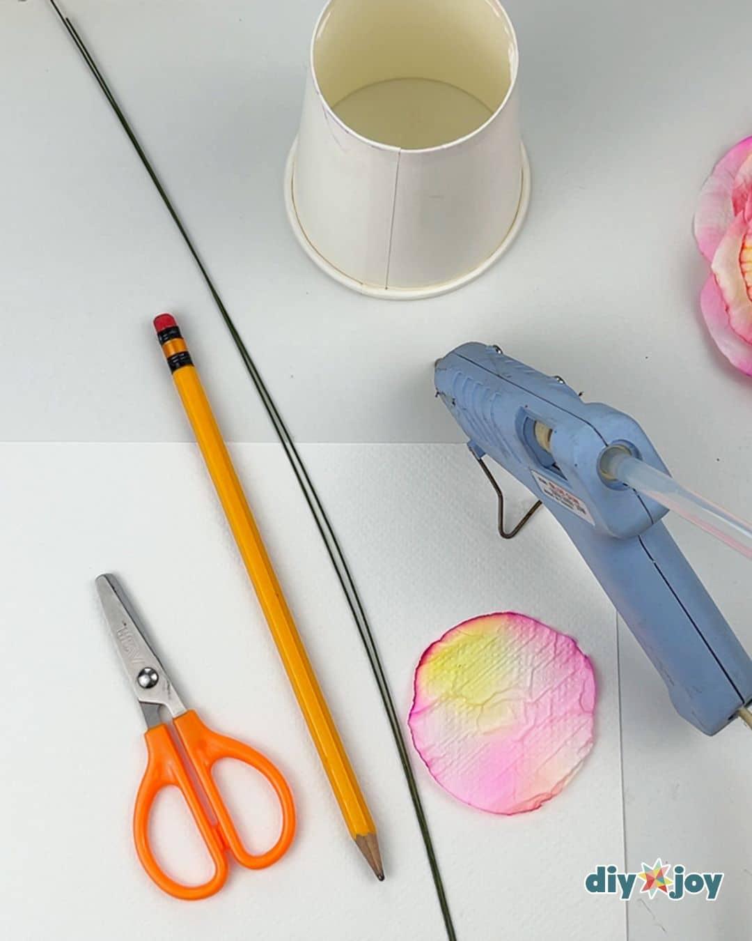 Toilet paper rose craft for beginners, one finished handmade paper flower shown close up on a plain table