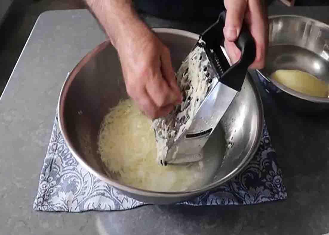Grating the potatoes for the potato pancake poppers recipe