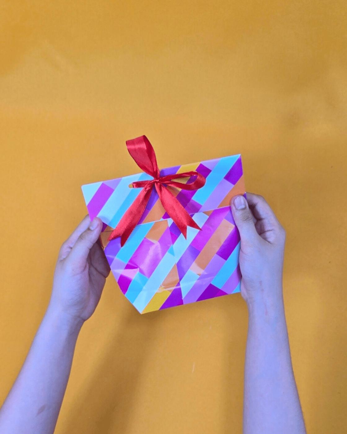 Easy DIY Gifts - finished diagonal stripe paper gift bag tied shut with a red ribbon bow