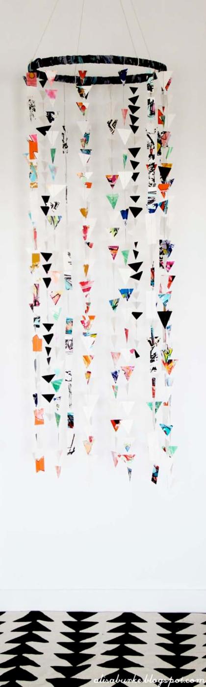 Paper mobile with an embroidery hoop and long sewn strands of tiny multicolored paper triangles hanging down