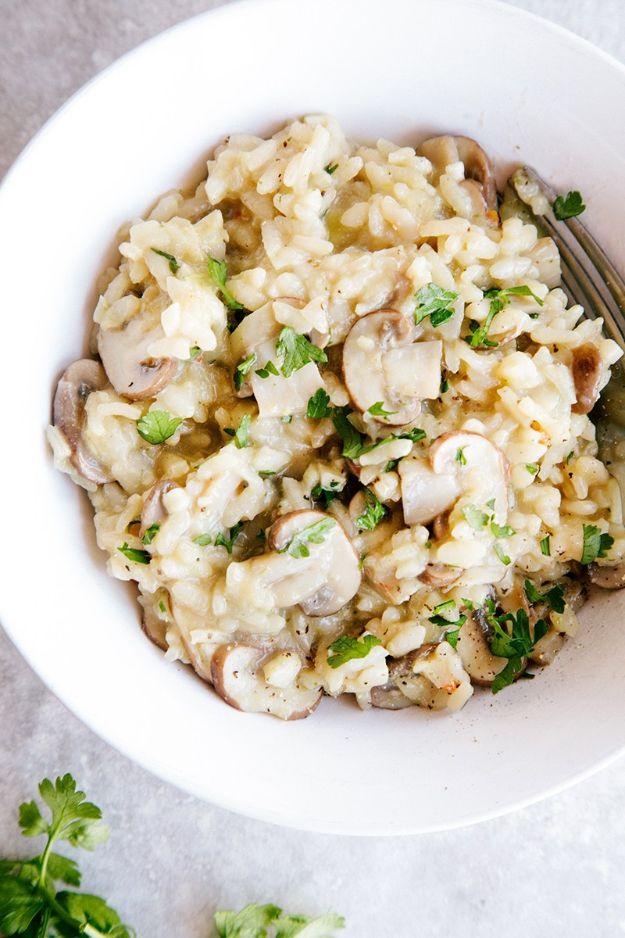Creamy vegan mushroom risotto in a shallow white bowl with sliced mushrooms and chopped fresh parsley