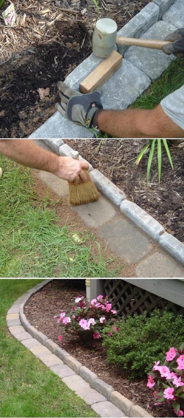 DIY curb appeal brick edging where gloved hands tap gray concrete pavers into a flower bed border beside pink flowers