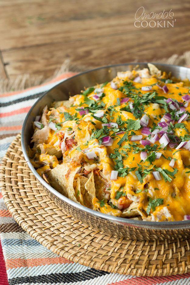 Rotisserie chicken nachos in a cast iron skillet with melted cheddar, pepper jack, cilantro and onion