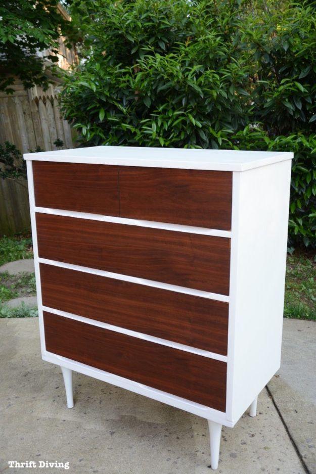 Tall dresser with white painted body and rich walnut drawer fronts on tapered white legs, photographed outside by a fence
