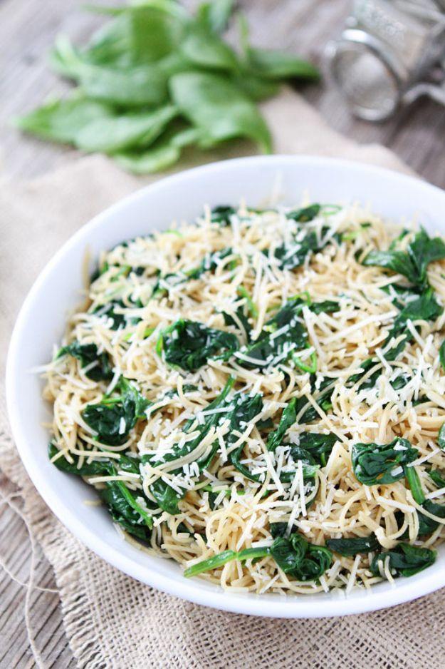 Five ingredient spinach parmesan pasta in a white bowl, spaghetti tossed with wilted spinach and grated cheese