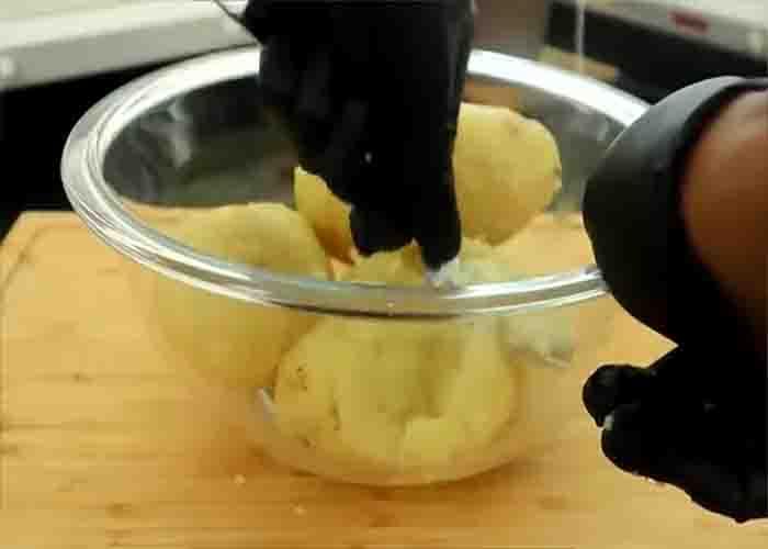Mashing the potatoes for the mashed potato cakes recipe