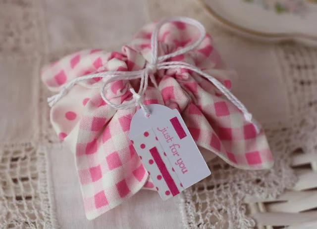 A small pink gingham fabric pouch gathered with white twine and finished with a just for you paper tag