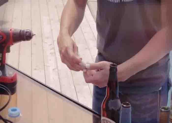 Assembling the DIY tiki torches using beer and wine bottles