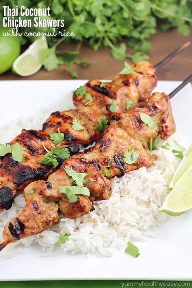 Thai coconut chicken skewers on a bed of white coconut rice with fresh cilantro and a wedge of fresh lime