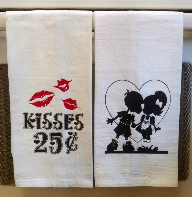 Plain kitchen towel decorated with a stenciled red heart hanging on an oven door handle, an easy handmade Valentine gift idea