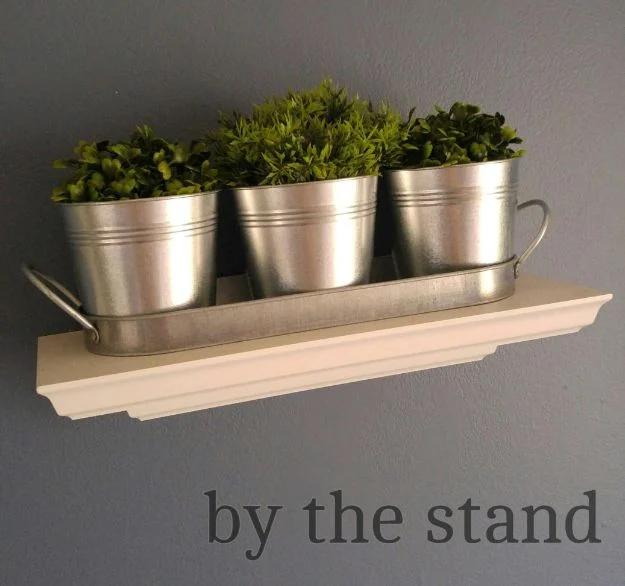 Dollar store farmhouse decor graphic with three galvanized pots of greenery in a tray on a white ledge