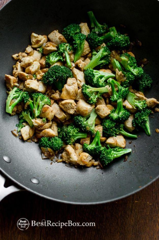 Low fat chicken and broccoli stir fry in a black wok, browned chicken pieces with bright green broccoli florets