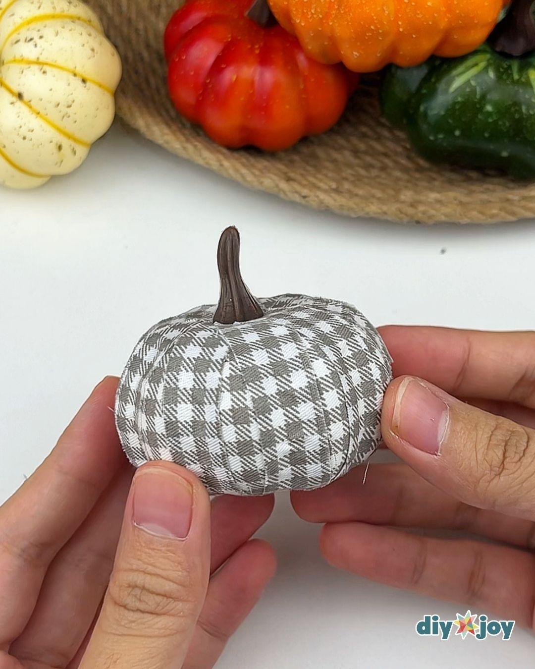 Best DIY Fall Crafts - side view of the finished gray gingham pumpkin with its brown stem pushed back into place