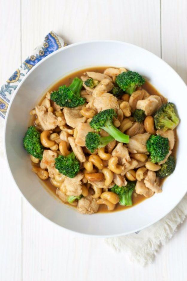 One pan broccoli cashew chicken in a white bowl, sliced chicken, florets and whole cashews in a glossy brown sauce