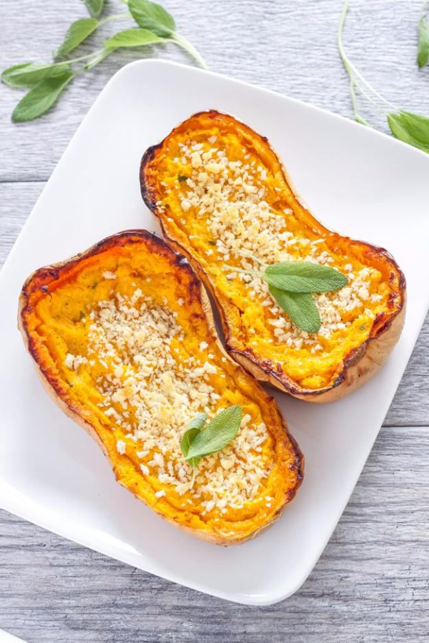 Twice baked butternut squash halves on a white platter, mashed filling topped with browned panko and sage