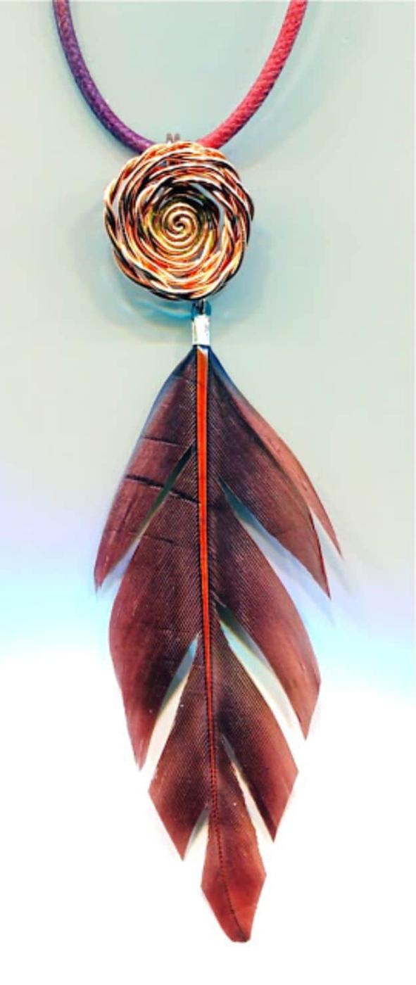 Wire rose pendant, a coiled copper wire rose on a purple cord hanging above a long copper feather charm