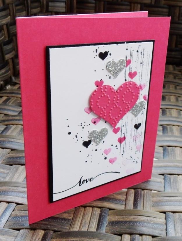 Grunge Valentines card stamped with splattered pink lines and scattered hearts on black and white cardstock