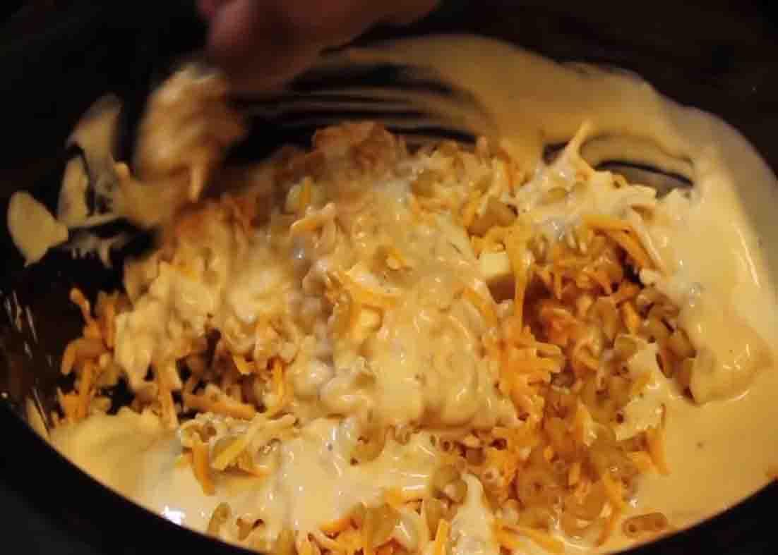 Mixing all the macaroni and cheese ingredients in the slow cooker