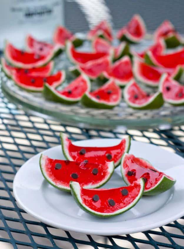 Watermelon lime jello shots set in hollowed lime halves with mini chocolate chip tips pressed in as seeds