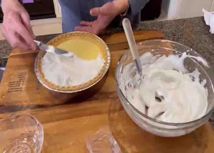 Adding the meringue over the lemon pie