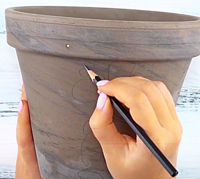 Sketch The Coy Fish Onto A Clay Pot Before Painting With Acrylics