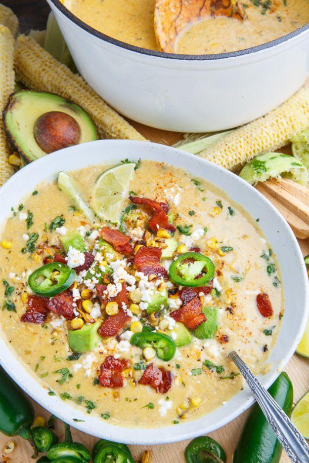 Mexican street corn soup in a white bowl topped with bacon, jalapeno slices, cotija, lime and cilantro