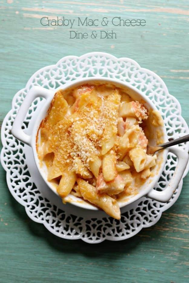 Typeset graphic reading Crabby Mac and Cheese Dine and Dish over a white scalloped bowl of crab macaroni