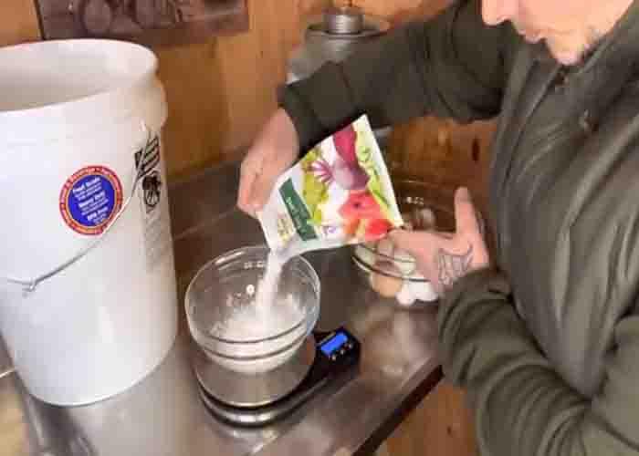 Adding the hydrated lime to the bucket where the eggs will be stored