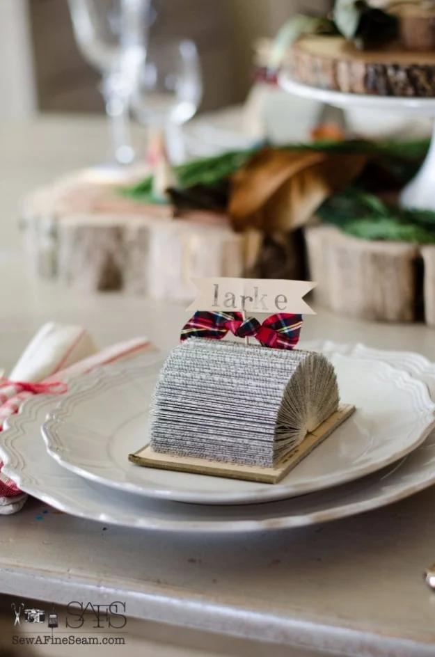 Place card holders made from old books, a glittered fanned book block with plaid ribbon holding a name card