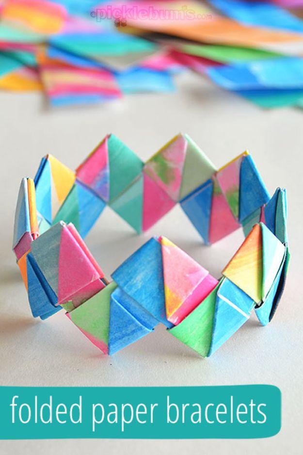 Folded paper bracelet of interlocked painted paper triangles under a typeset folded paper bracelets title band