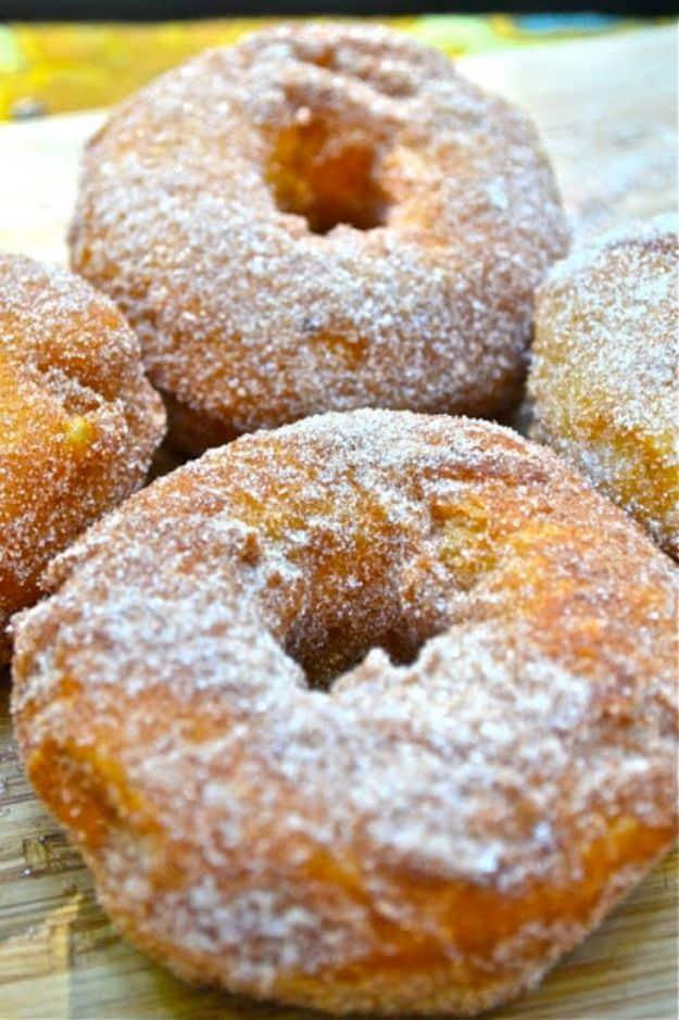 Cinnamon sugar doughnuts fried from canned biscuits in a cast iron skillet over a campfire, an easy canned biscuit recipe