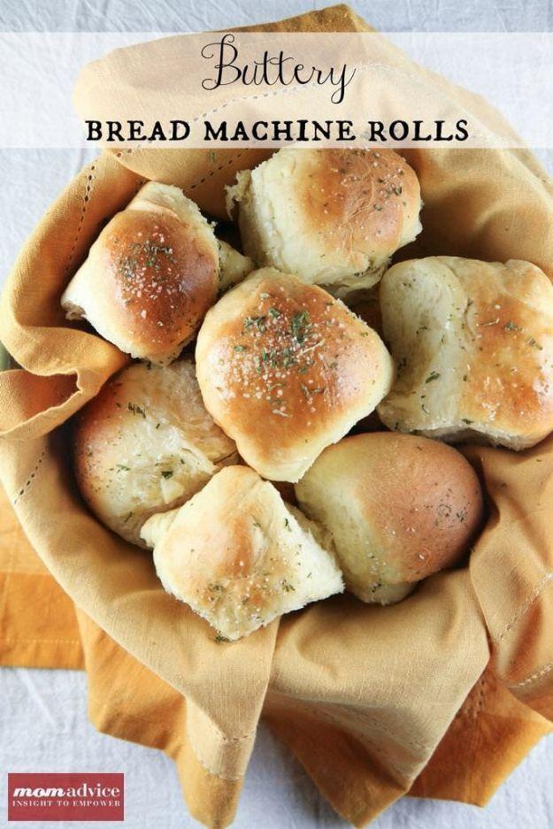 Buttery bread machine dinner rolls baked light golden in a pan and brushed with butter and dried herbs