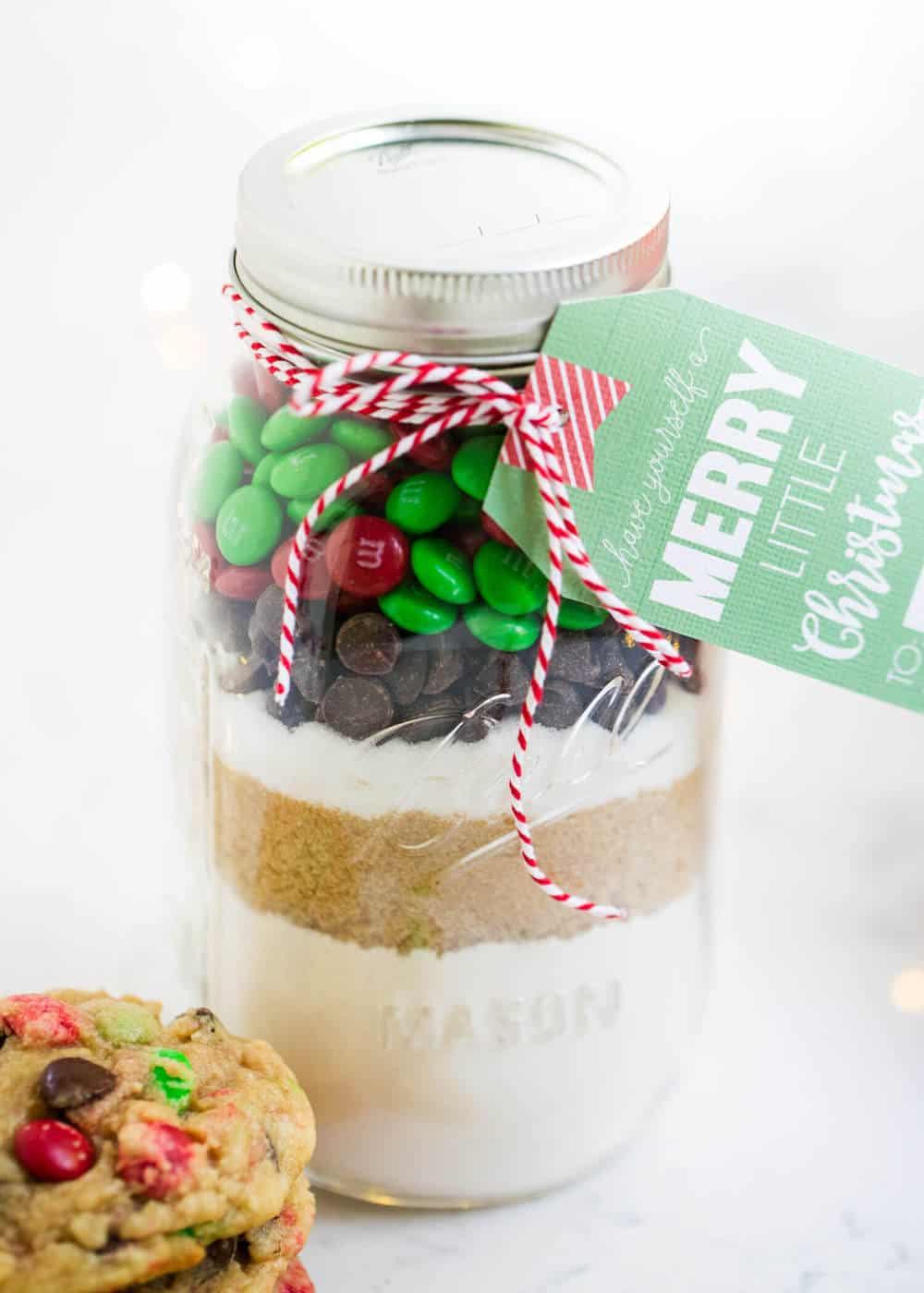 Quart mason jar layered with flour, brown sugar, chocolate chips and red and green candies, tied with a gift tag