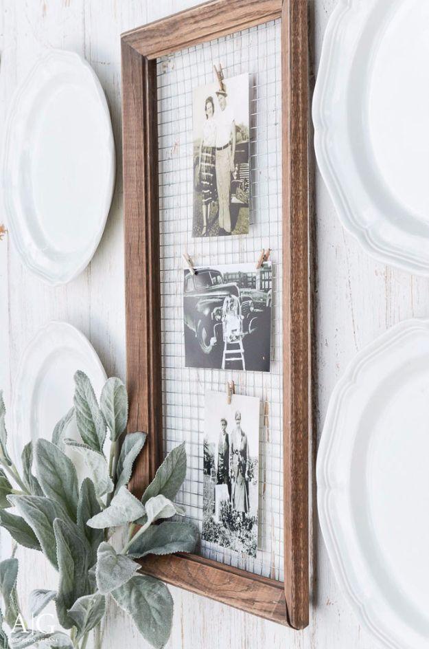A wood frame strung with twine and small clips holds several photographs, propped on a shelf against a neutral wall