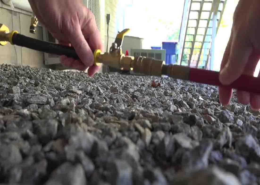 Using an air compressor to drain the hose of water.