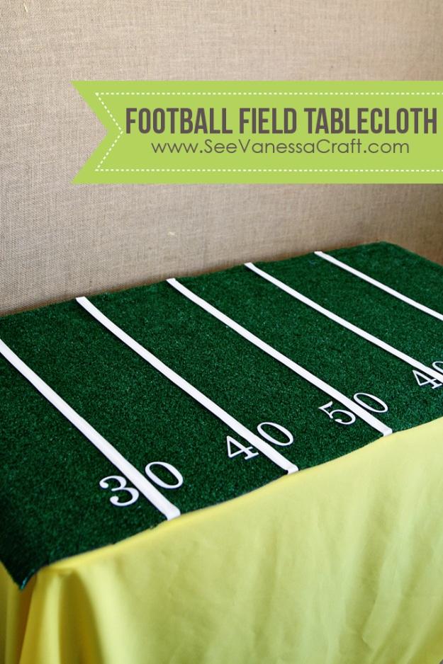 Table covered in artificial turf marked with white tape yard lines and vinyl numbers, over a yellow tablecloth