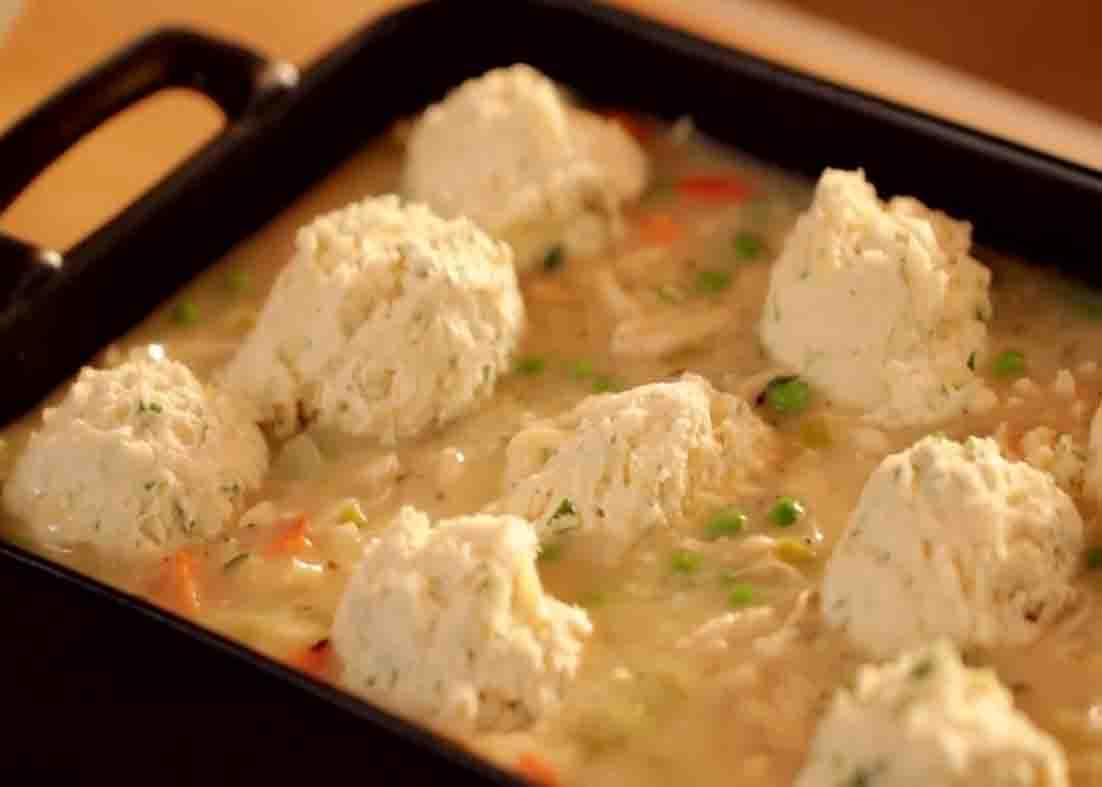 Adding the biscuit on top of the chicken casserole