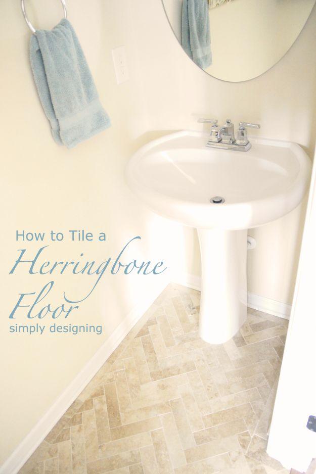 Herringbone bathroom tile floor, rectangular travertine tiles laid in herringbone around a white pedestal sink