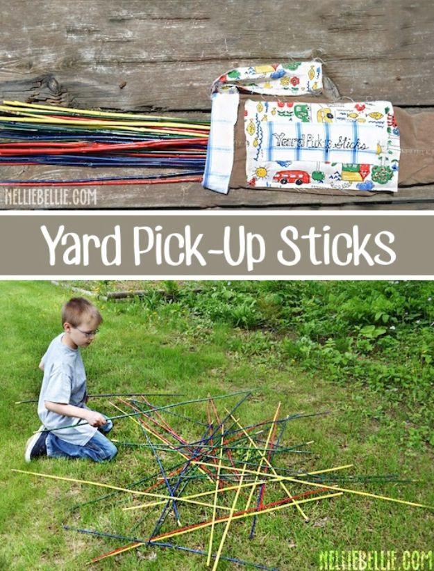 Giant pick up sticks in red yellow blue and green scattered across a green lawn ready for an outdoor game