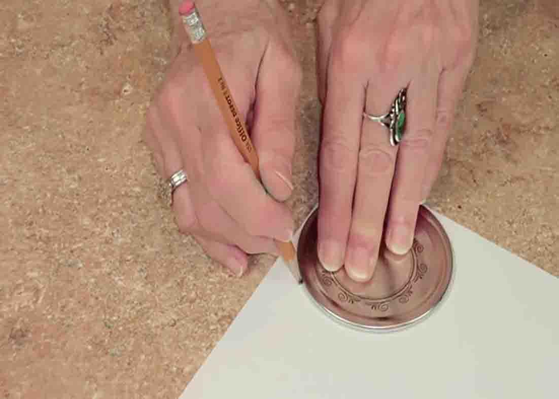 Tracing the jar lid onto the scrapbooking paper