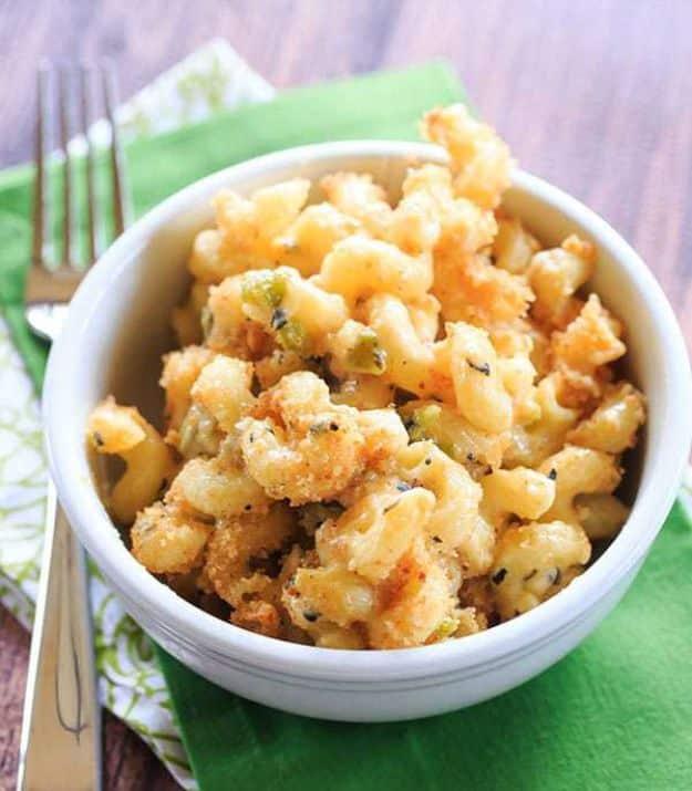 Hatch chile mac and cheese in a white bowl with a golden breadcrumb top, set on a bright green cloth napkin