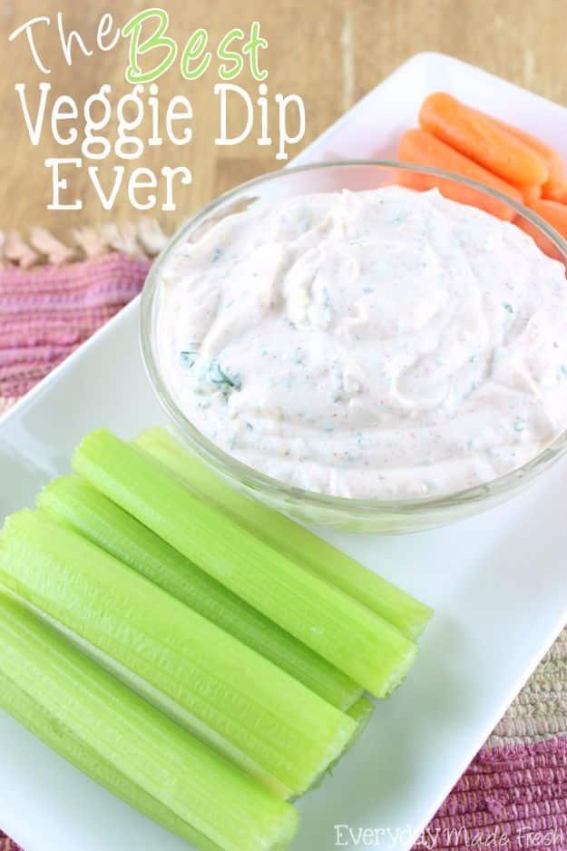 Best veggie dip in a bowl dusted with smoked paprika beside carrot sticks, celery and bell pepper strips