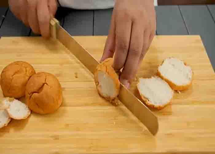 Slicing the buns for pizza hut's supreme garlic bread