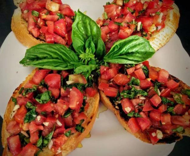Tomato and basil bruschetta spooned onto toasted baguette slices with garlic, olive oil and balsamic