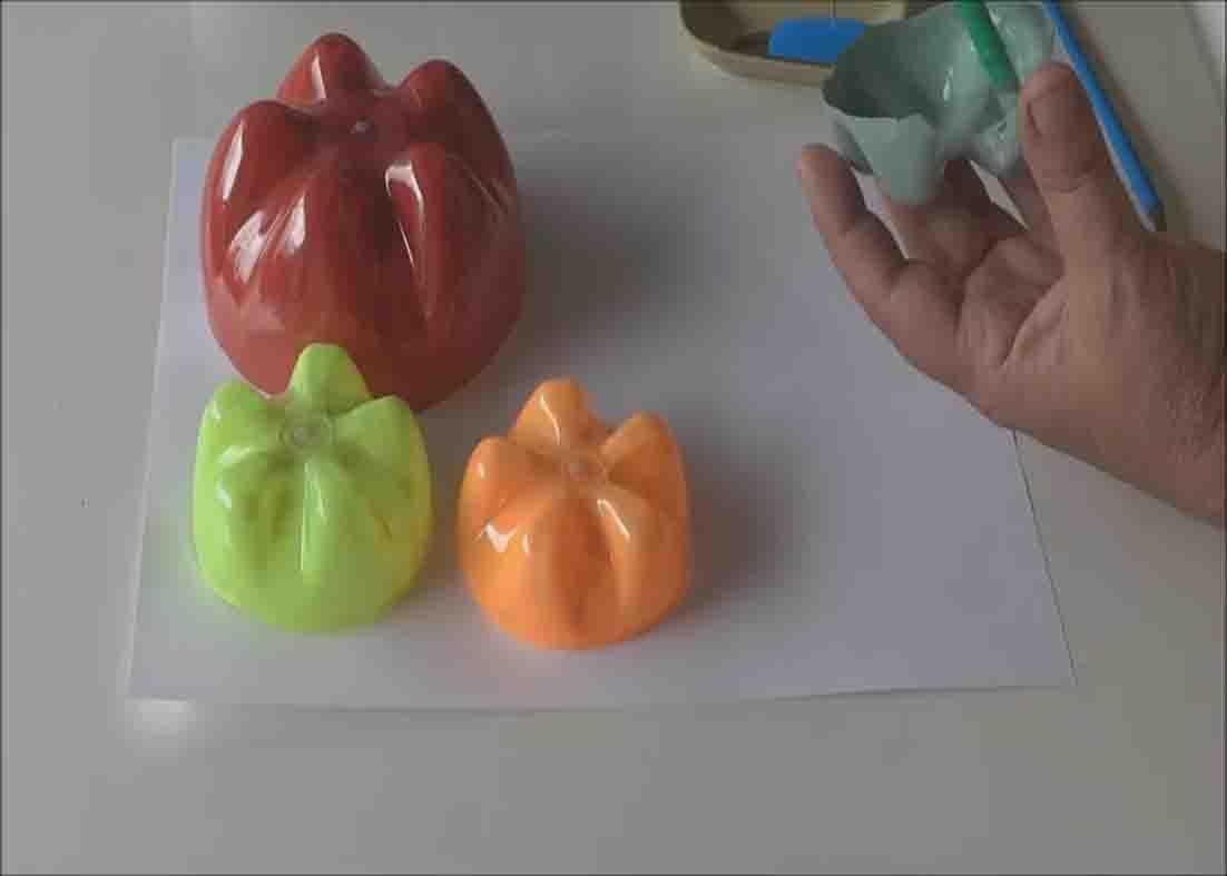 Painting the ladybugs to make the DIY ladybug family using plastic bottles