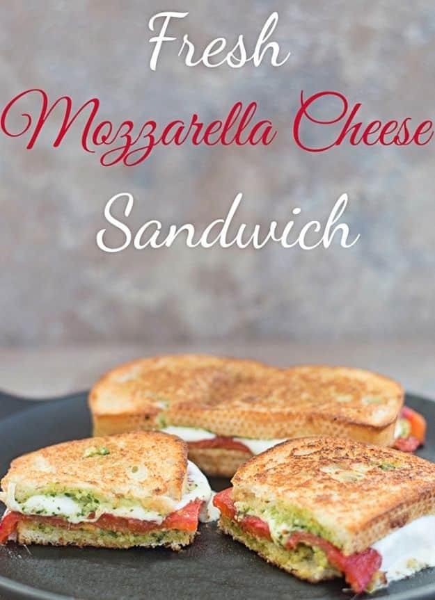 Fresh mozzarella cheese sandwich with roasted red pepper strips and arugula pesto on grilled Italian bread