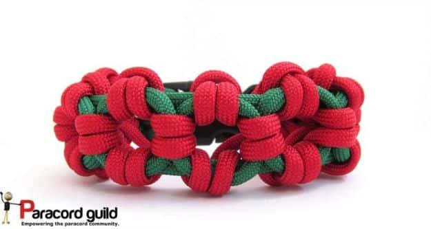Red and green Aztec sun bar paracord bracelet showing its stepped geometric bar, on a plain white background